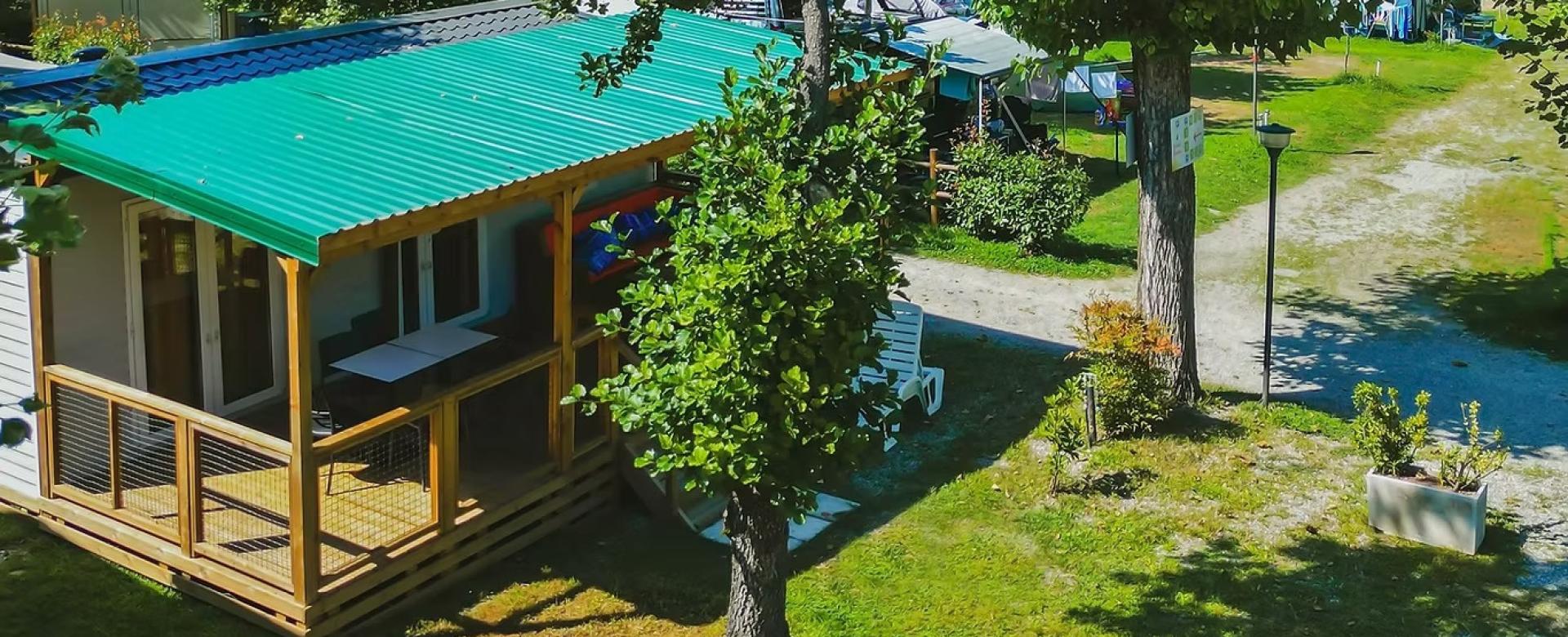 Casetta nel verde, tetto colorato, atmosfera serena e accogliente immersa nella natura rigogliosa.