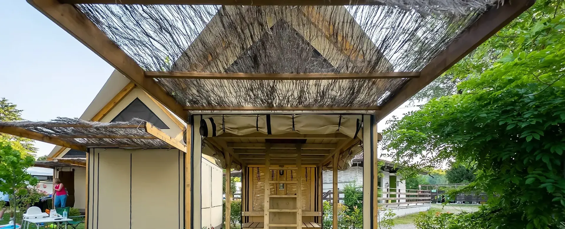 Struttura in legno e paglia, atmosfera rustica e naturale, immersa nel verde rigoglioso.