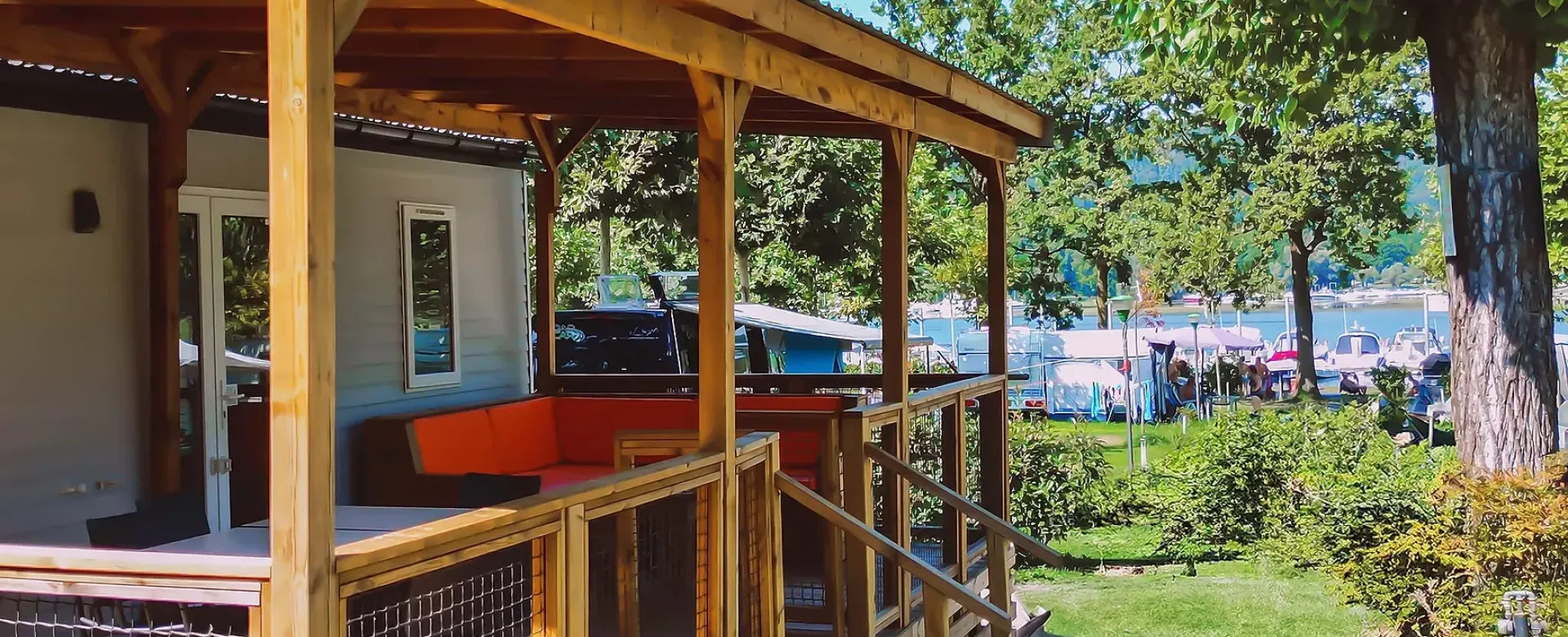 Veranda in legno, relax all'aperto, vista lago, natura rigogliosa, atmosfera serena e accogliente.