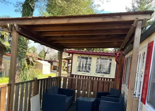 Terrazza in legno, arredi moderni, atmosfera rilassante immersa nella natura.