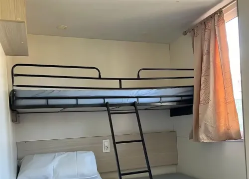 Camera semplice e luminosa con letto a castello, atmosfera accogliente e serena.