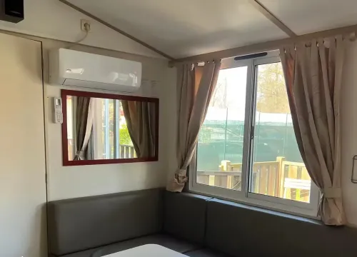 Interno accogliente con divano, tavolo e luce naturale, atmosfera calda e rilassante.