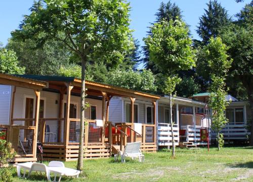 Bungalow in legno immersi nel verde, sotto un cielo azzurro, atmosfera di relax estivo.