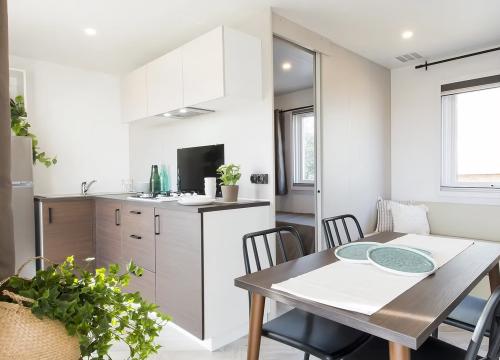 Cucina moderna luminosa, elegante, con dettagli naturali e accogliente sala da pranzo.