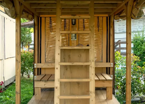Struttura in legno all'aperto, accogliente e rustica, con scale e piante circostanti.