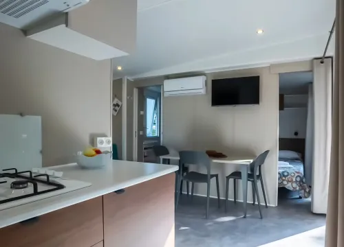 Interno moderno e luminoso di una casa mobile con cucina e tavolo da pranzo.