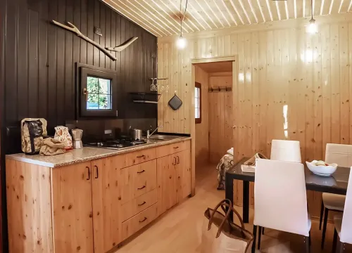 Accogliente cucina in legno, atmosfera calda e rustica con dettagli eleganti e moderni.
