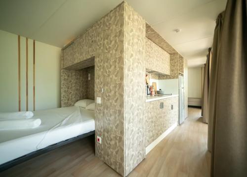 Camera moderna e accogliente con letto e cucina, atmosfera calda e rilassante.