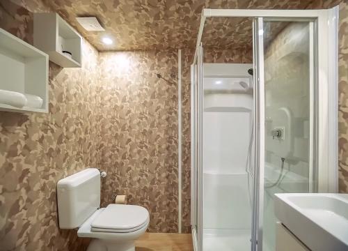 Bagno moderno con doccia e pareti mimetiche, atmosfera calda e accogliente.