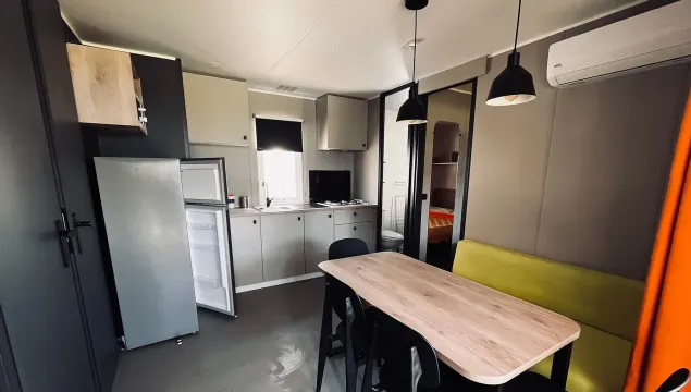Cucina moderna e luminosa, tavolo accogliente, atmosfera calda e invitante.