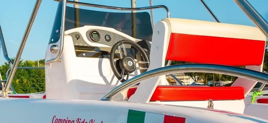 Barca bianca con sedili rossi, sole splendente, atmosfera estiva e avventurosa sul Lago Maggiore.