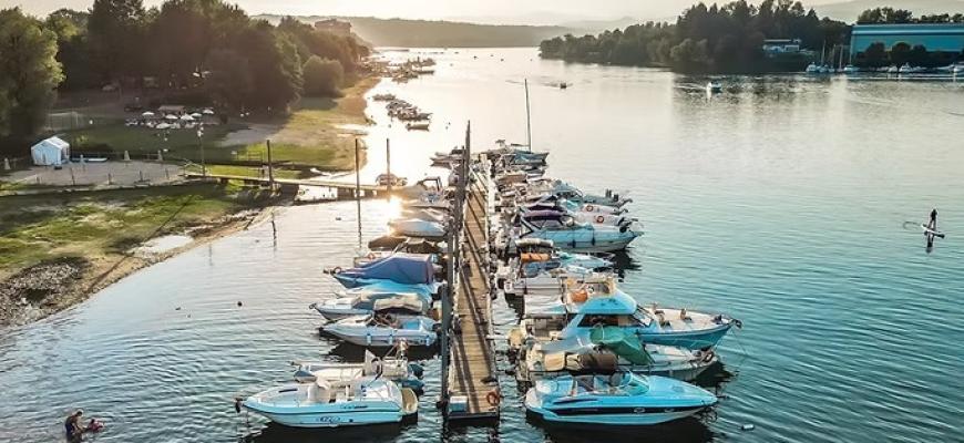 Barche ormeggiate al tramonto, atmosfera serena e rilassante sul lago tranquillo.